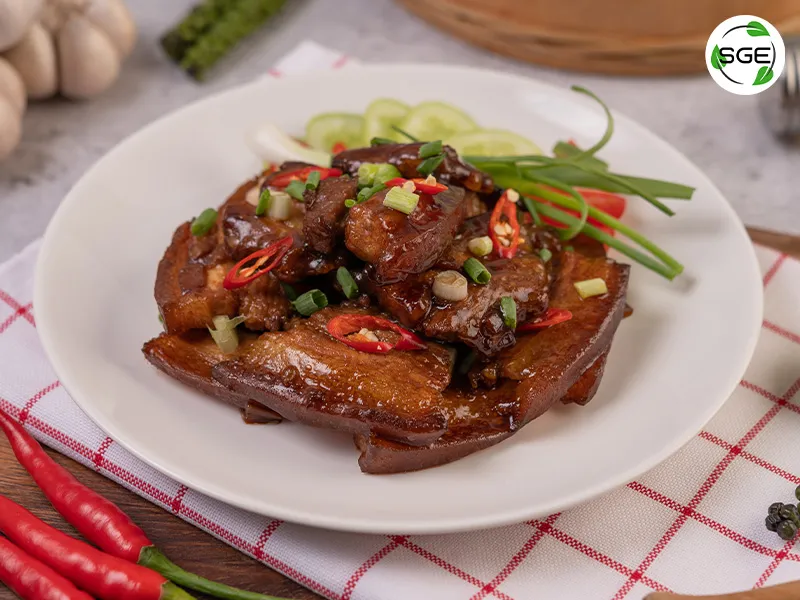 หมูอบน้ำผึ้ง หมูสามชั้นอบน้ำผึ้งอยู่ในจานสีขาว
