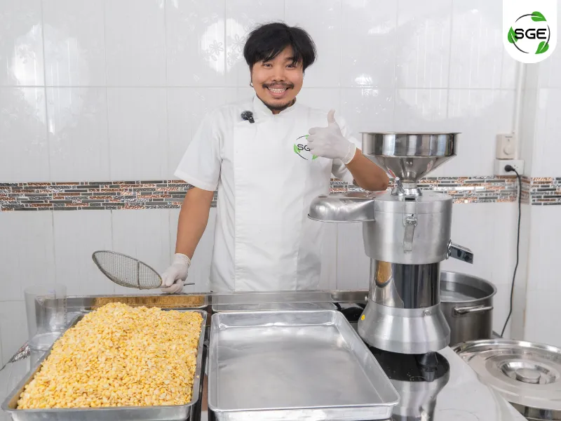 ถั่วเหลืองวางอยู่ในถาด พร้อมเครื่องทำน้ำเต้าหู้แยกกาก