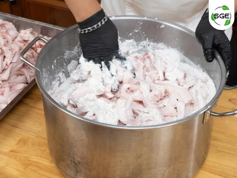 นำหนังหมูติดมันมาคลุกกับแป้งข้าวเจ้า ผงฟู น้ำส้มสายชูและน้ำเปล่า นำหนังหมูติดมันมาคลุกกับแป้งข้าวเจ้า ผงฟู น้ำส้มสายชูและน้ำเปล่า